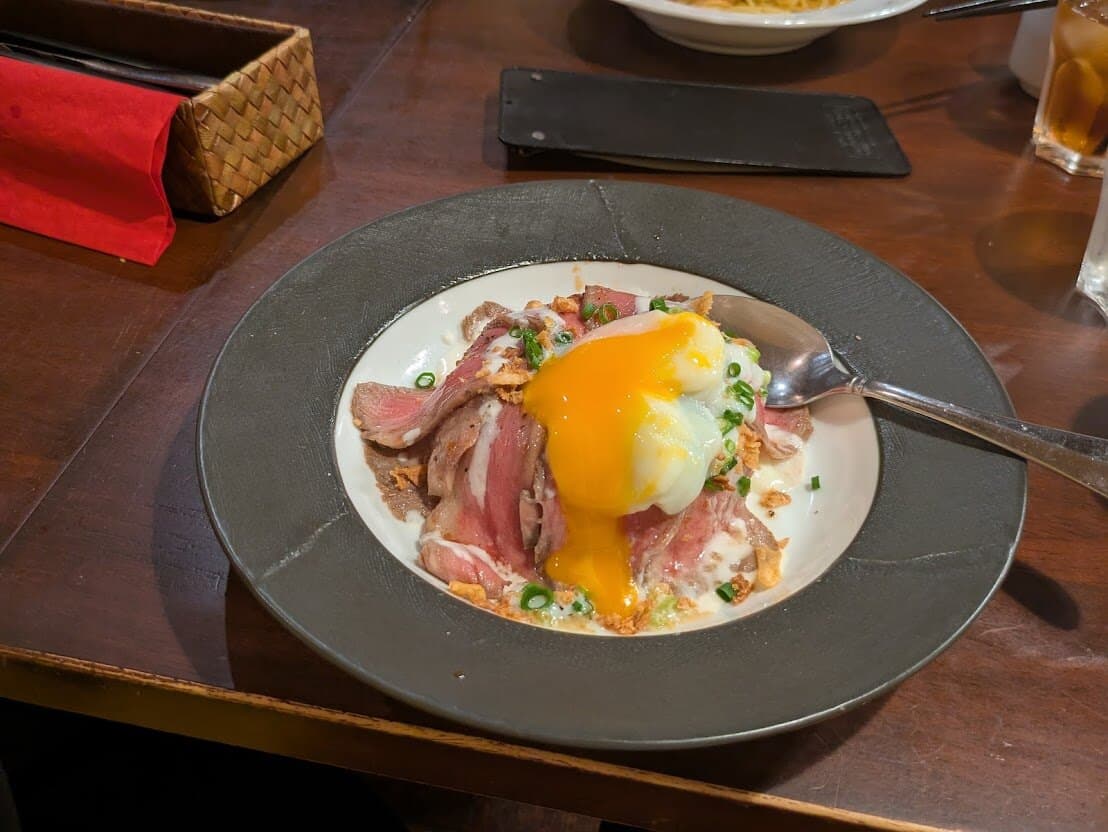 卵を割ったローストビーフ丼。黄身がとろけている