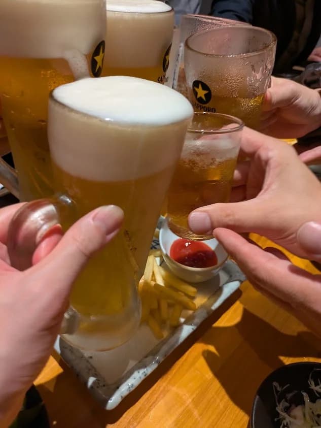 ビールのジョッキで乾杯する打ち上げの様子