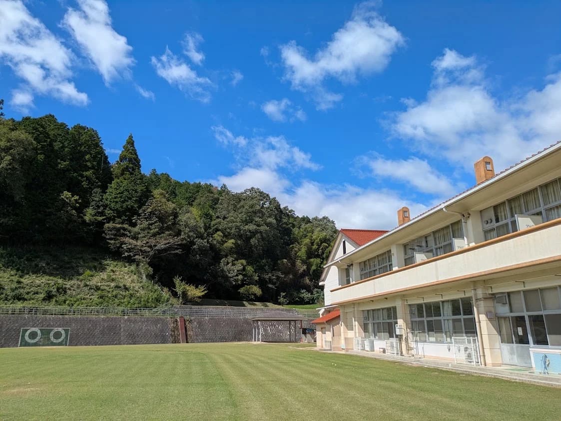 青空の下の会場の旧小学校と芝生の校庭