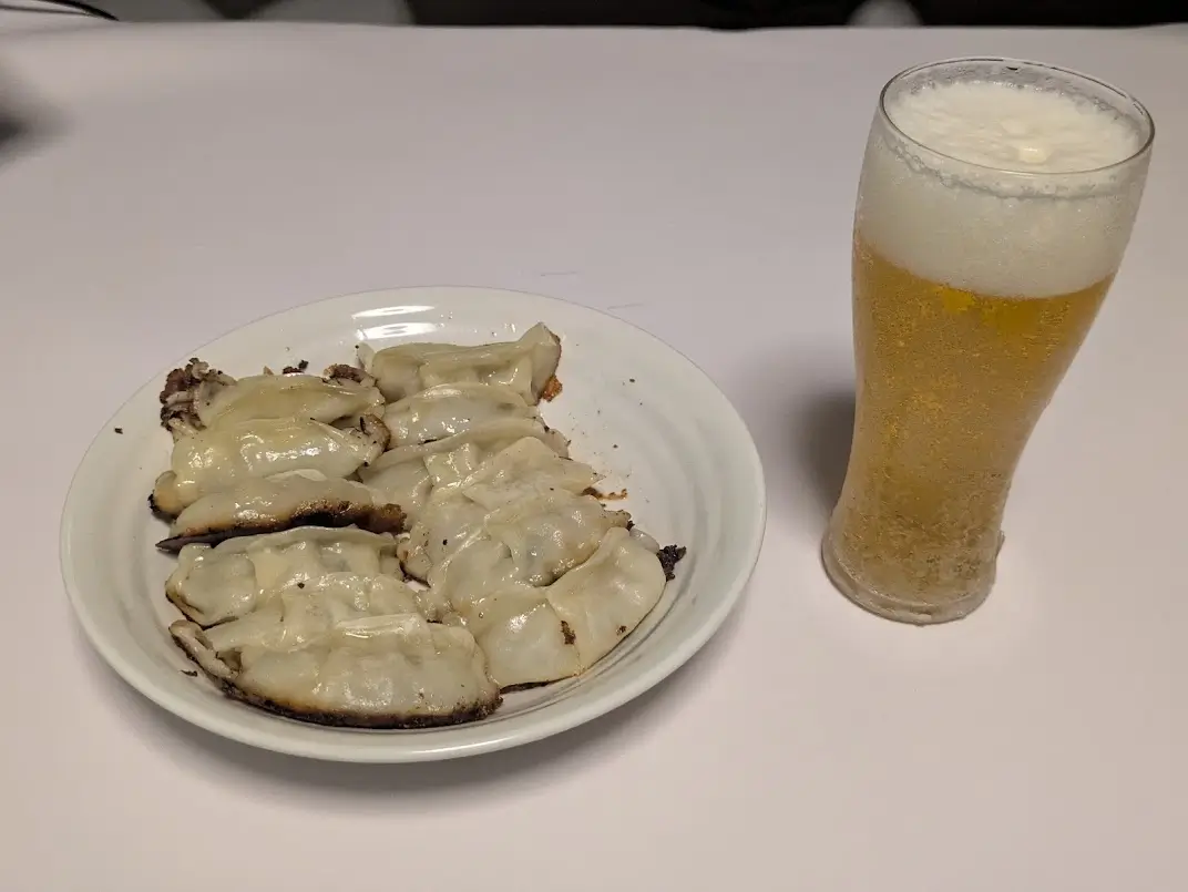 焼き上がった餃子とグラスに注いだビール